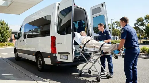 Liegend transportierte Person auf einer Fahrtrage beim Verladen in ein Fahrzeug, KI-generiert